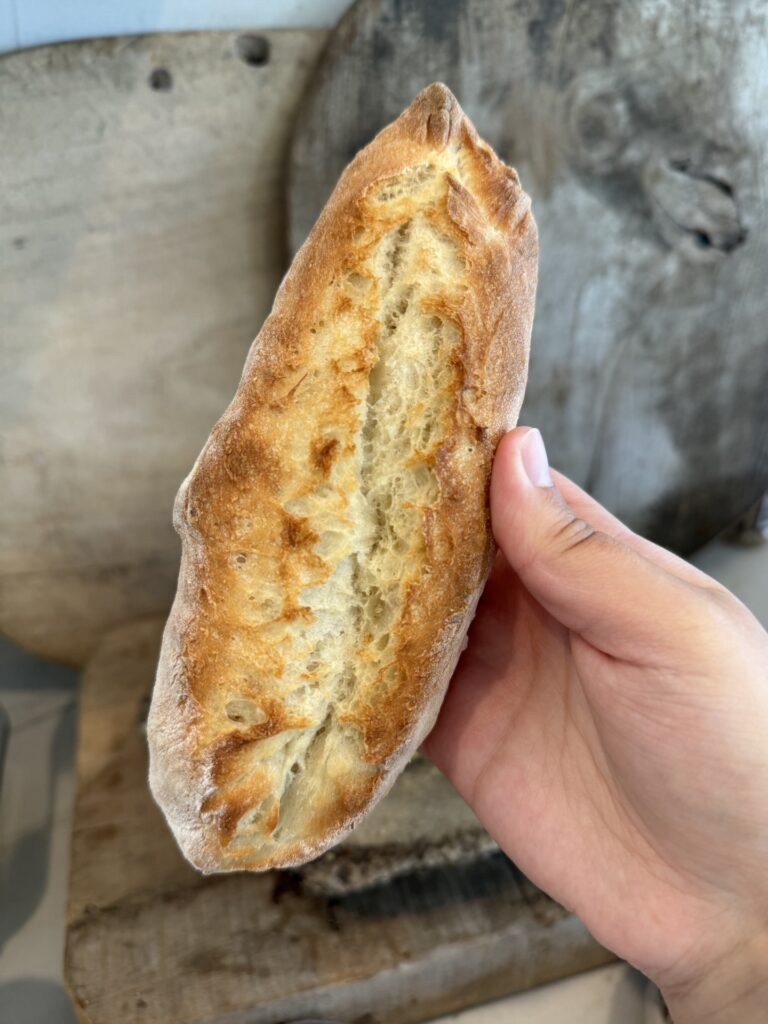 Fresh homemade baguettes with golden crust cooling on a wire rack.